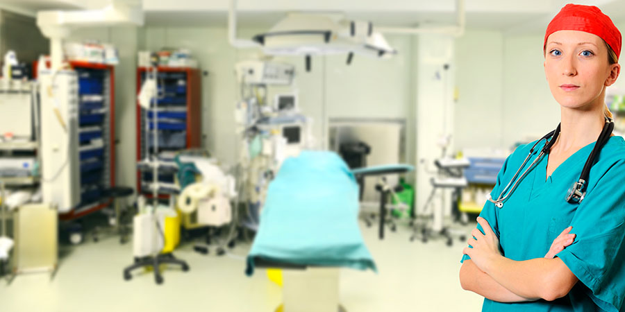 A perioperative nurse standing in an operating room.